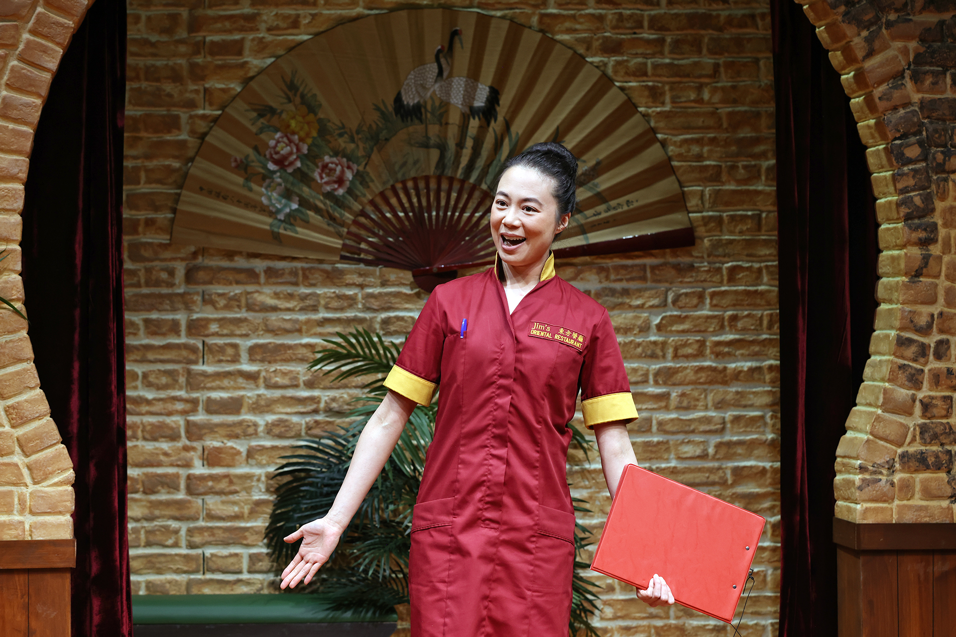 A woman in a uniform holding a red folder.